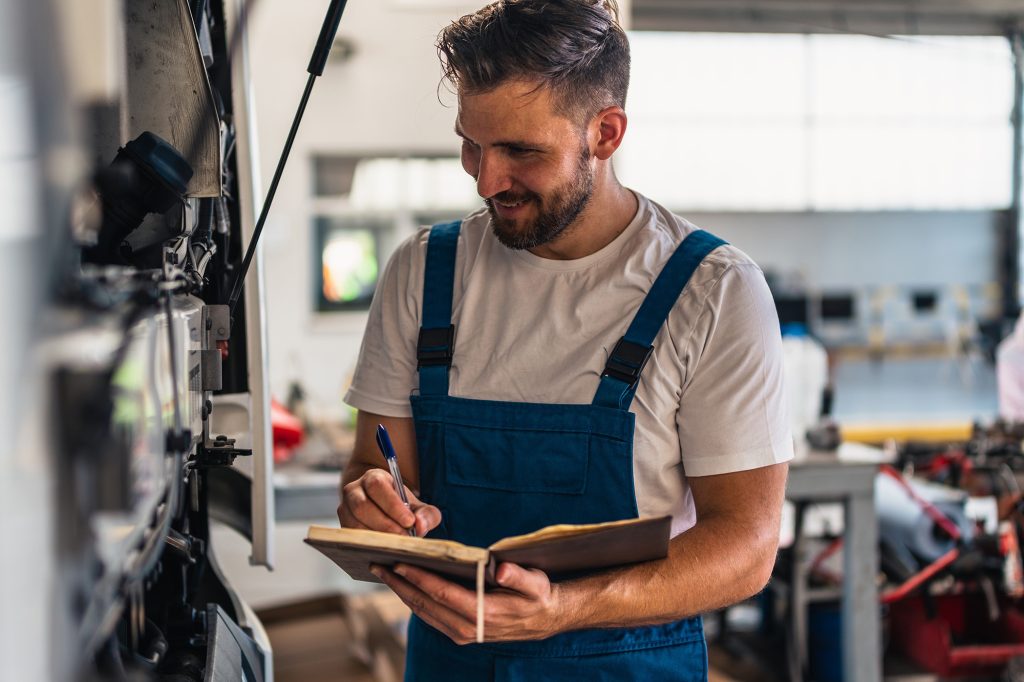 truck,mechanic,writing,notes,in,notebook,during,working,in,modern